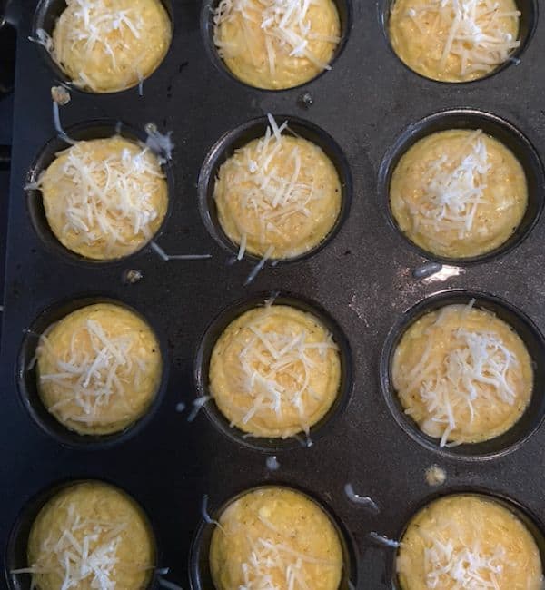 egg muffins pulled from oven after 10 minutes and topped with cheese