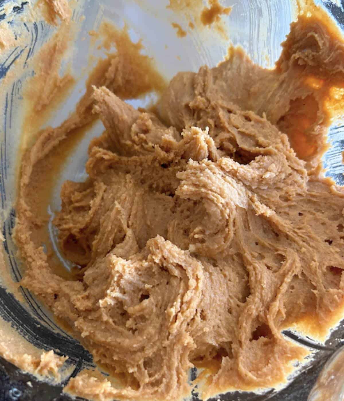 Peanut butter cookie batter in glass bowl.