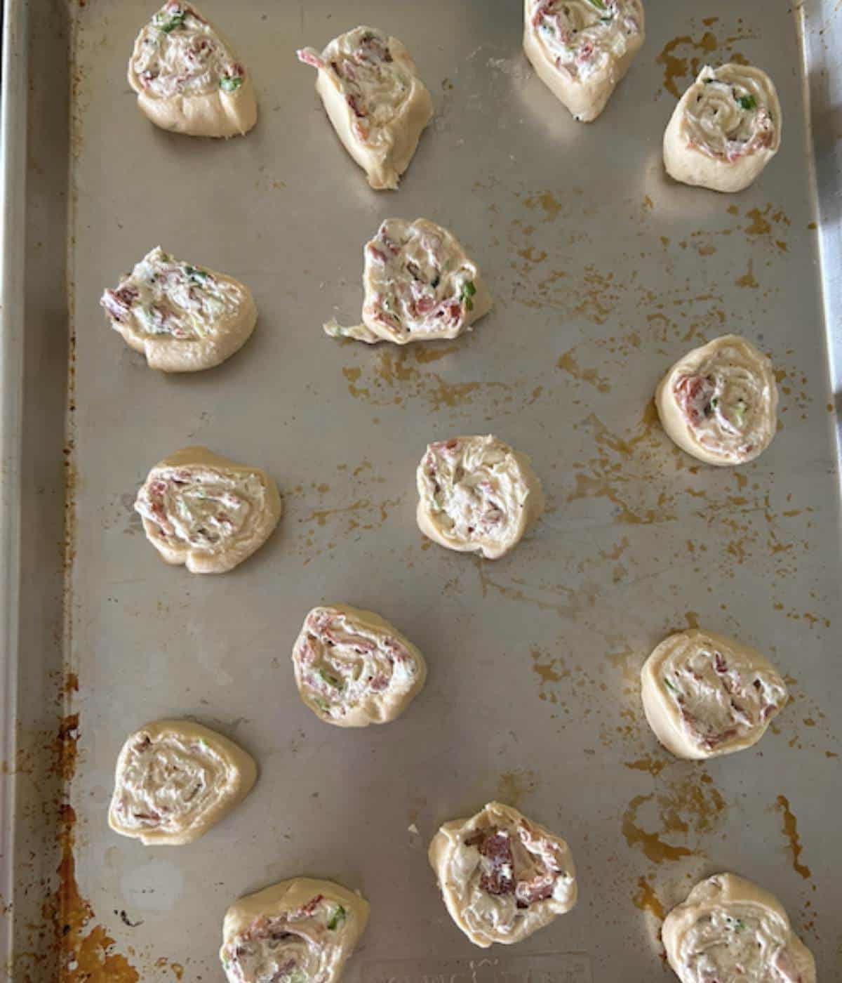 Bacon pinwheels on cookie sheet before baking.
