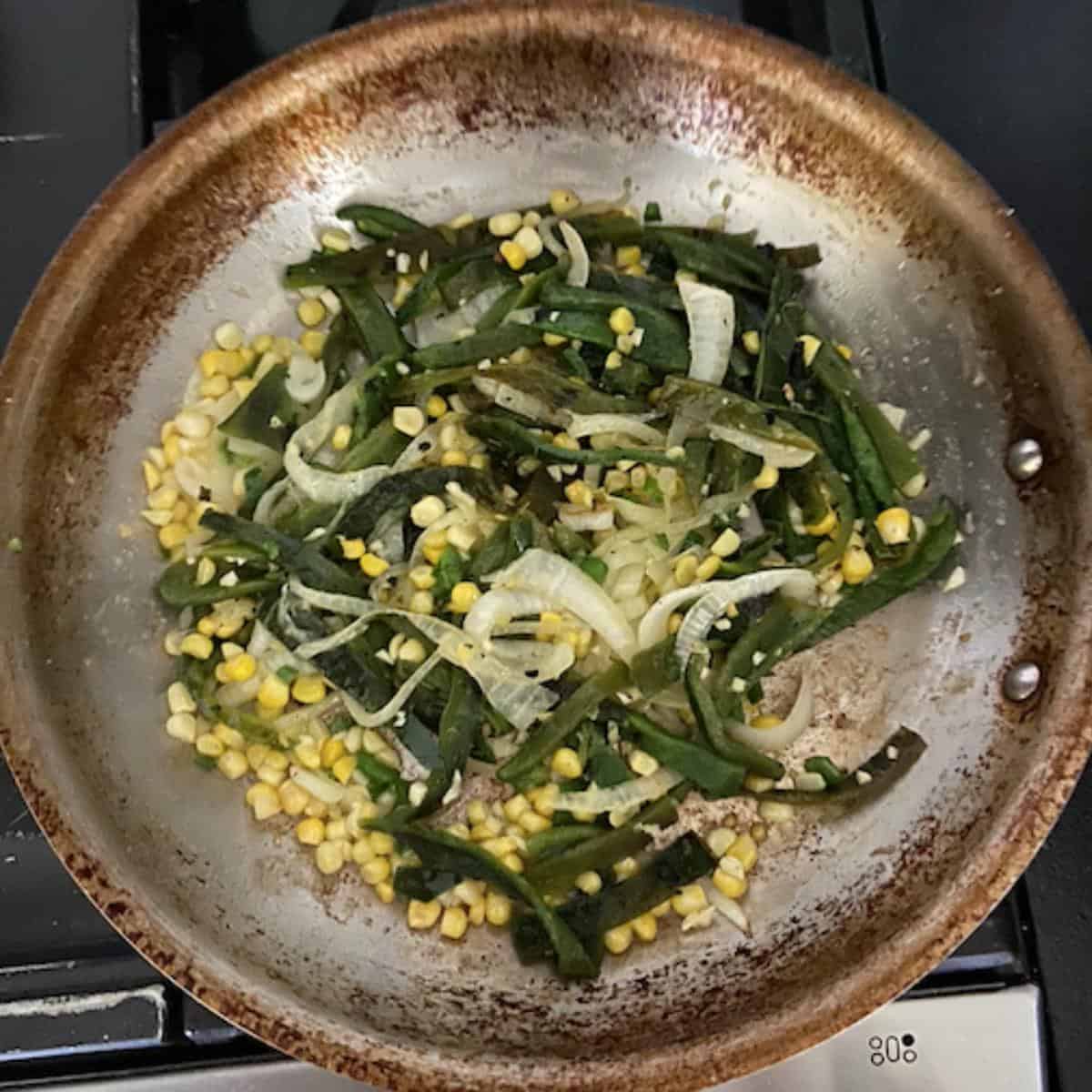 poblanos, corn, jalapeno, onion, and garlic in skillet