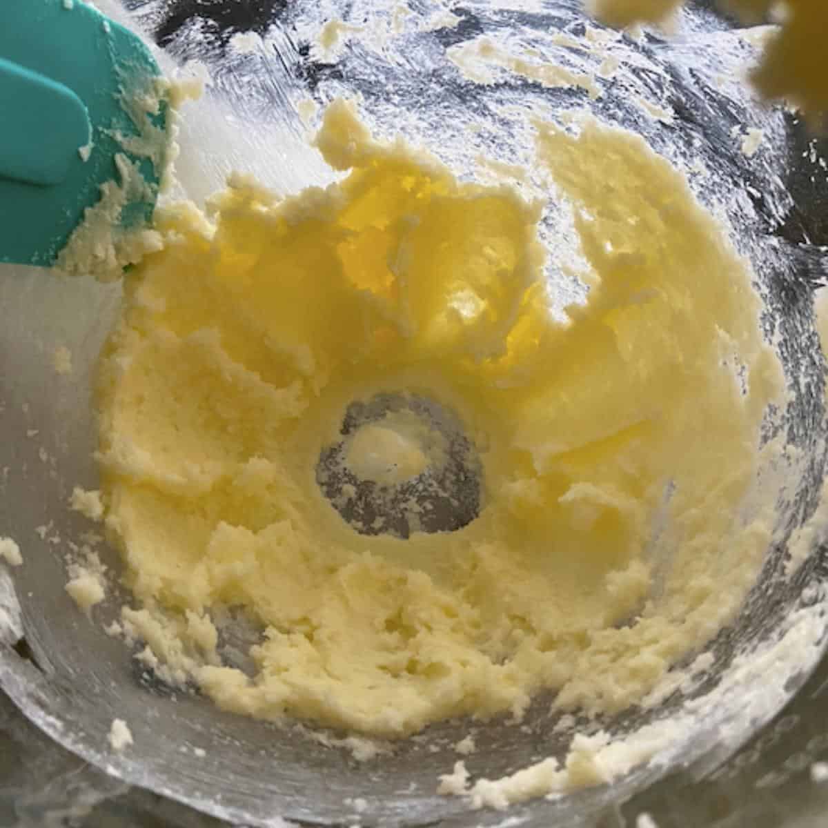 Sugar and butter creamed together in glass bowl.