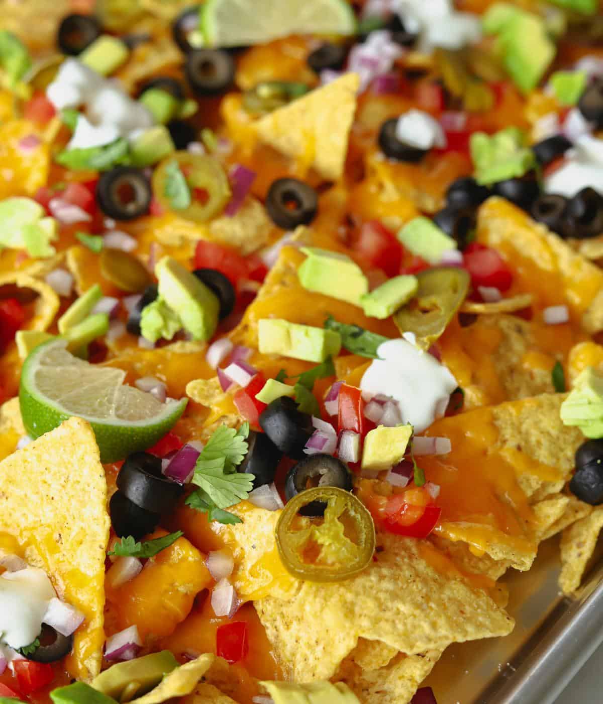 close up of vegetarian nachos with cheese and veggies
