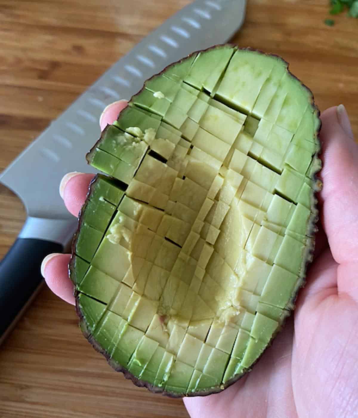 hand holding sliced avocado