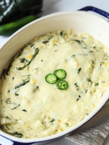 rajas con crema in casserole dish topped with sliced jalapeno
