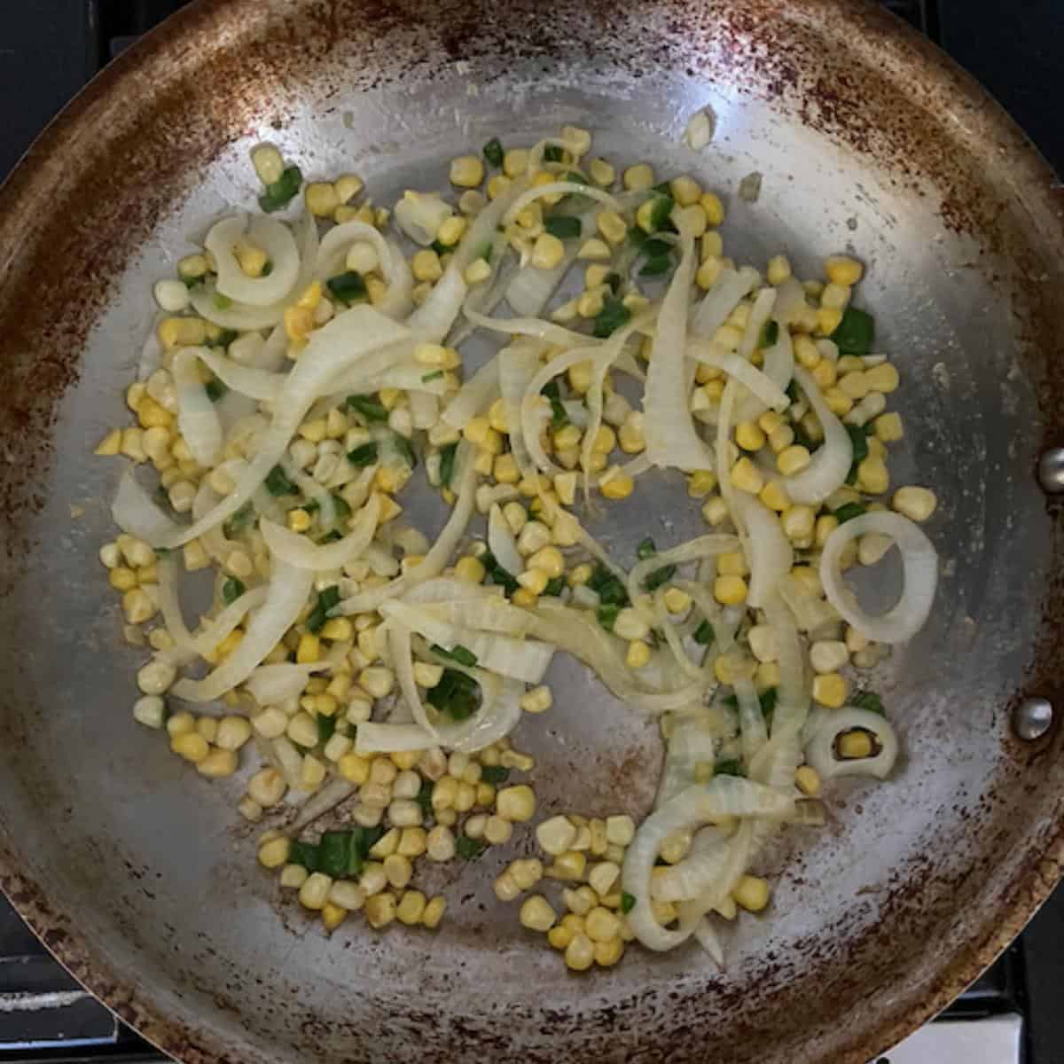 corn jalapeno and onion cooking in skillet