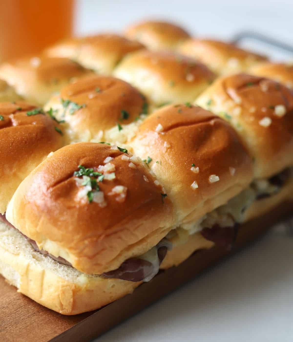 Hot Baked Roast beef sliders with horseradish sauce topped with garlic butter. 
