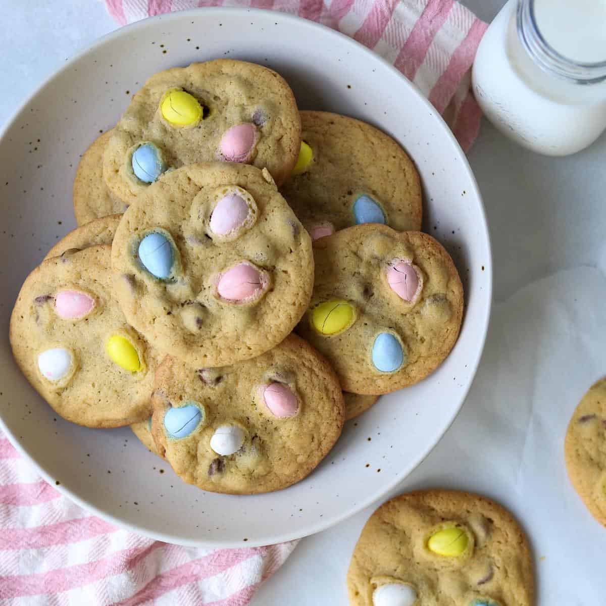 mini egg cookies in a bowl with a glass of milk
