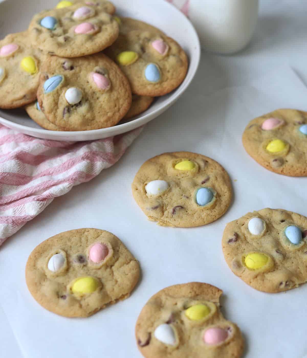 mini egg chocolate chip cookies on gray counter with bowl of cookies in background