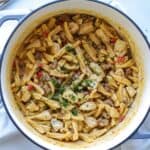 chicken and chorizo pasta in dutch oven topped with parsley