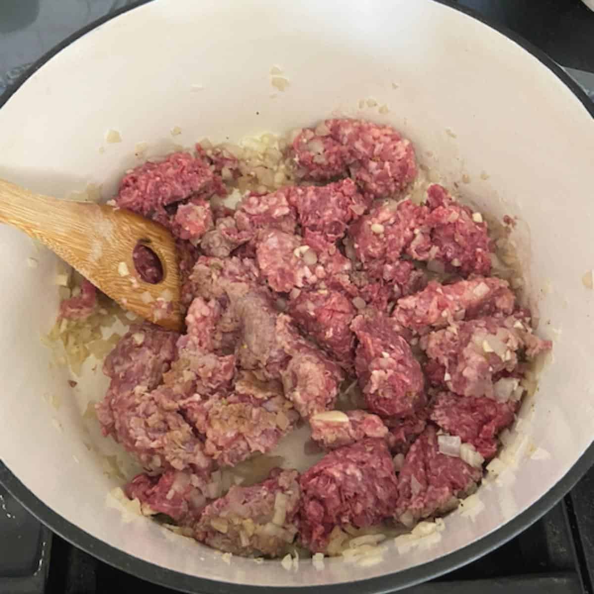 meat added to dutch over with wooden spoon
