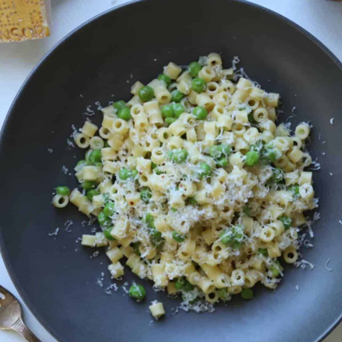 Pasta and peas in gray bowl. 