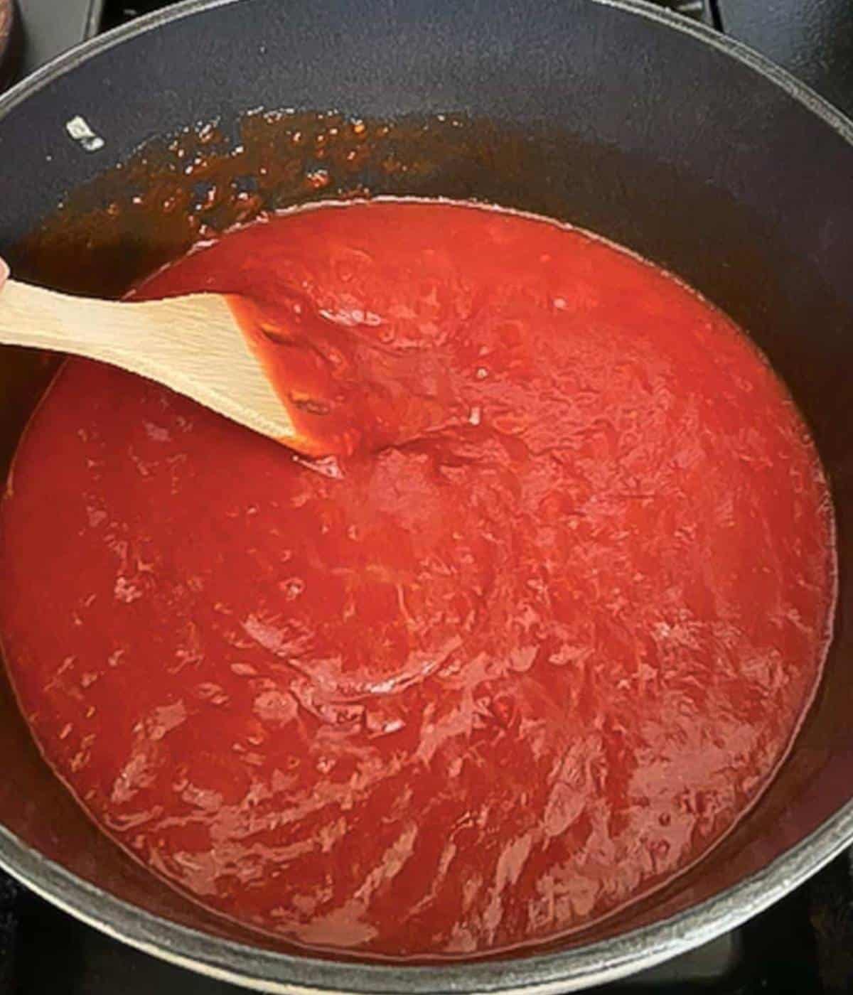 Stirring sauce with wooden spoon.