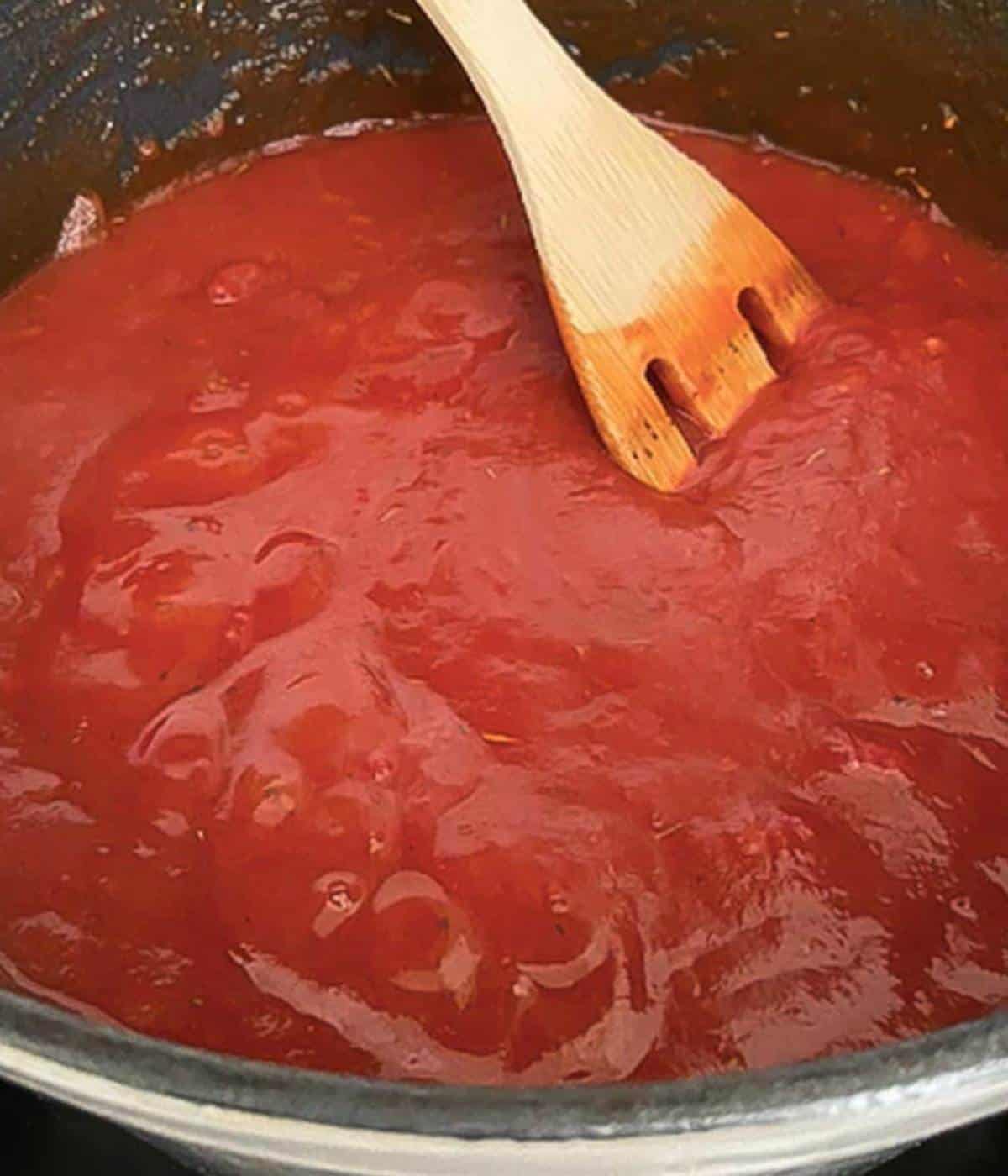 Stirring simmering San Marzano tomato pasta sauce.