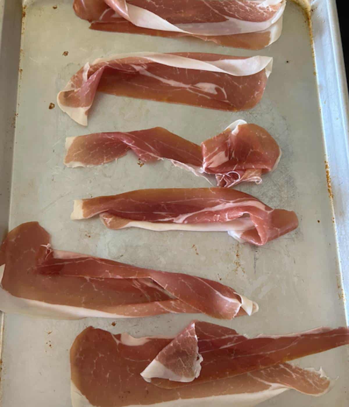 Prosciutto uncooked on baking tray.