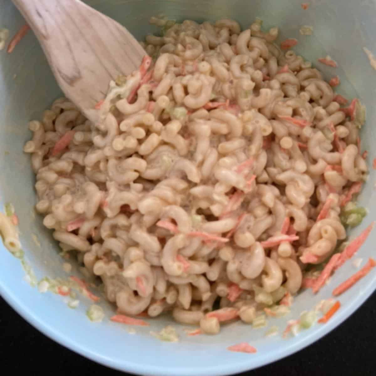 mixing sauce into macaroni salad