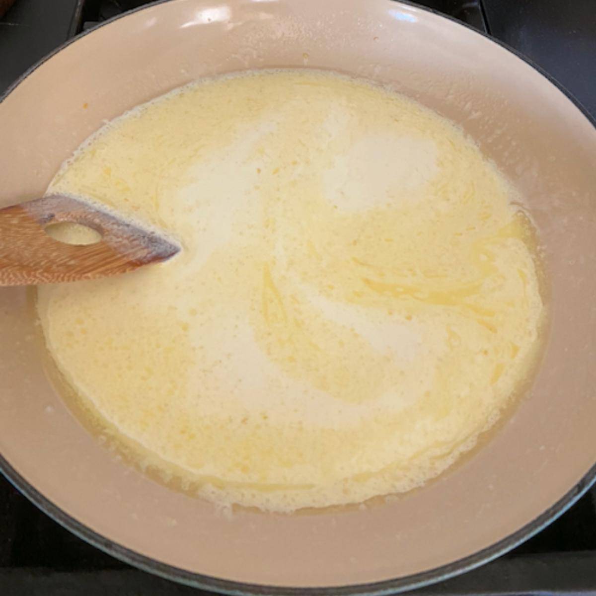 Cream and butter cooking in pan.