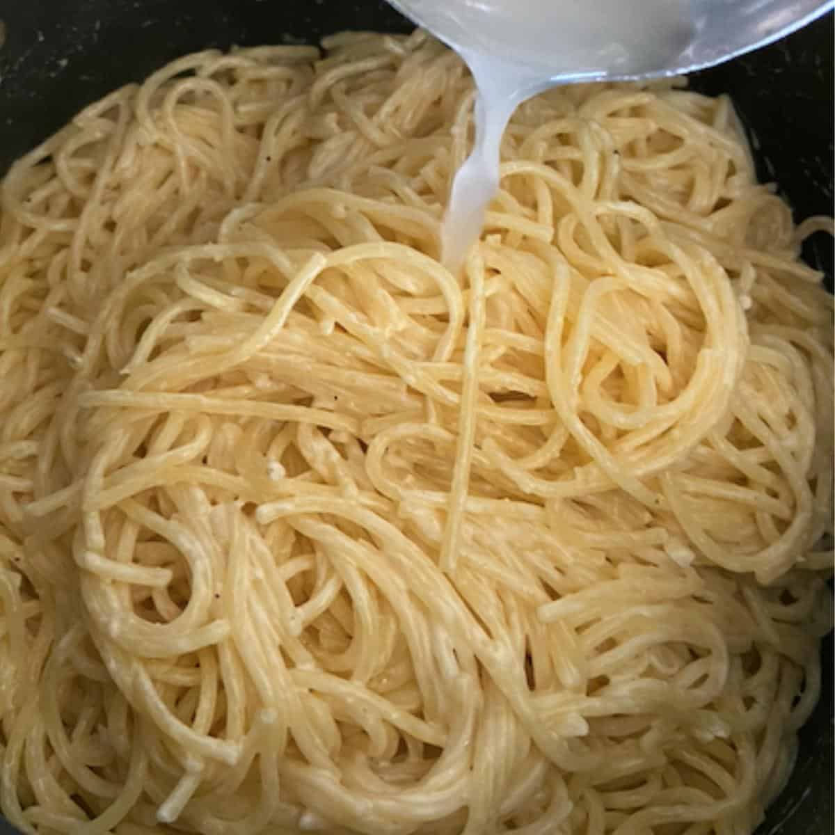 pasta water mixing into creamy pasta