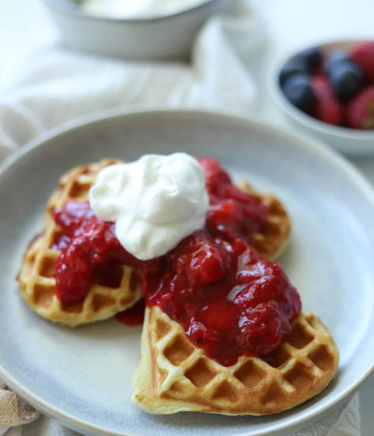 strawberry compote over heart waffles topped with whipped cream