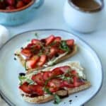 strawberry ricotta toast on plate with coffee in background