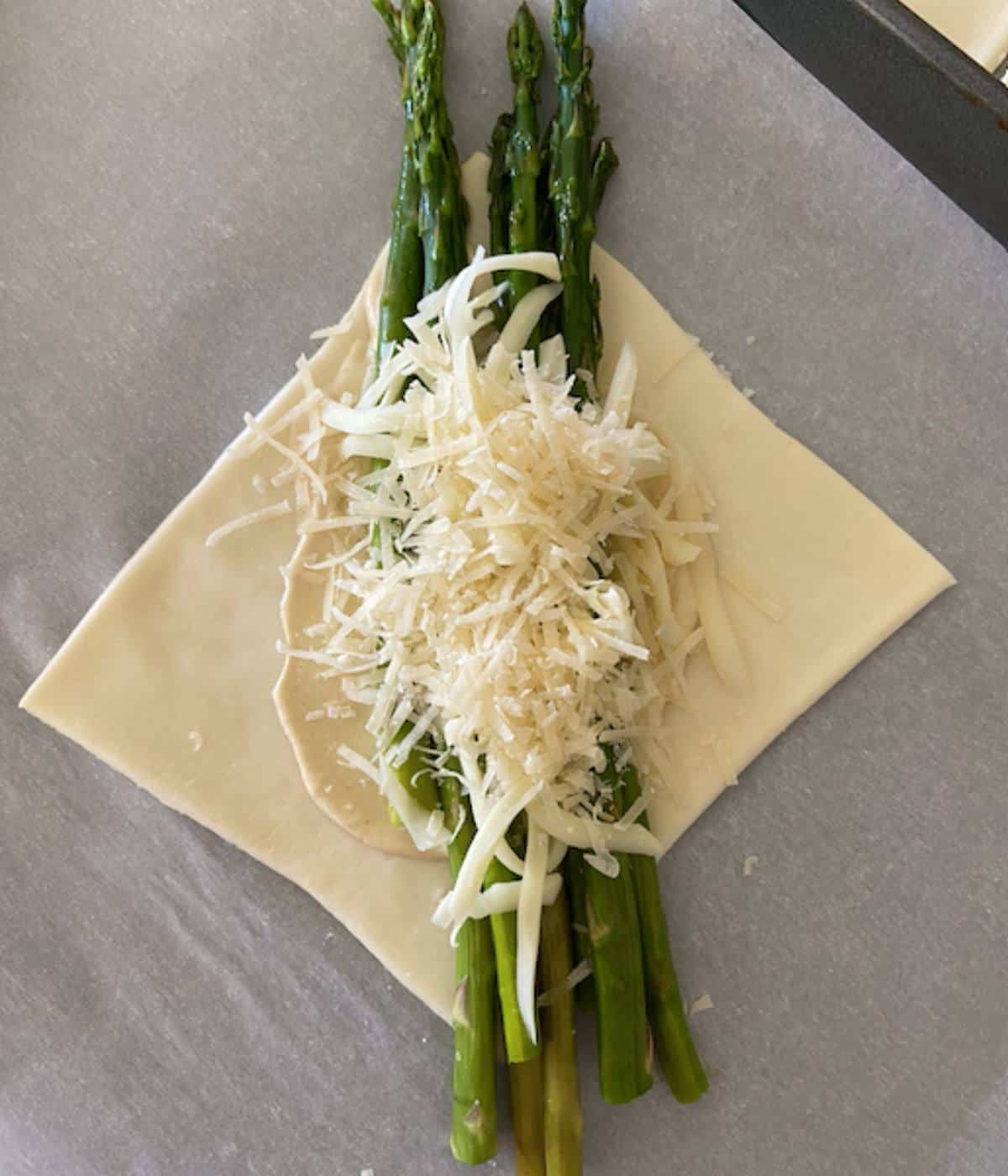 puff pastry square topped with asparagus and cheese.