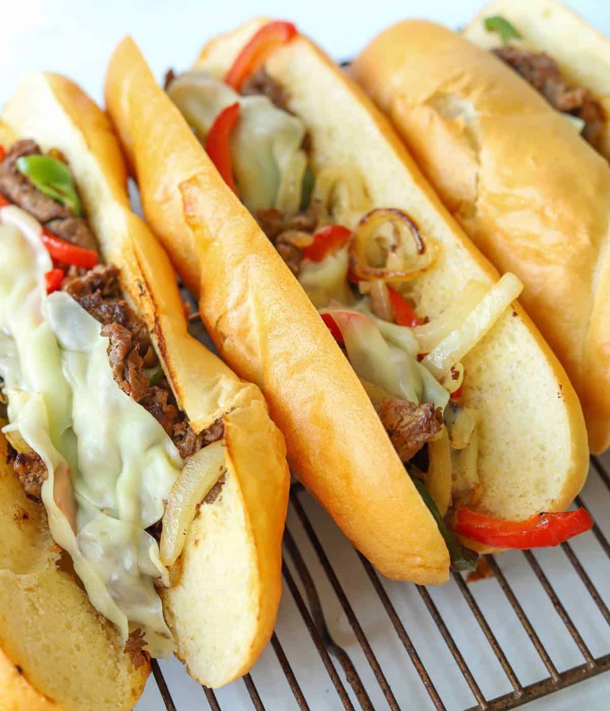 Hoagie rolls loaded with meat, cheese, peppers and onions for the perfect cheesesteak.