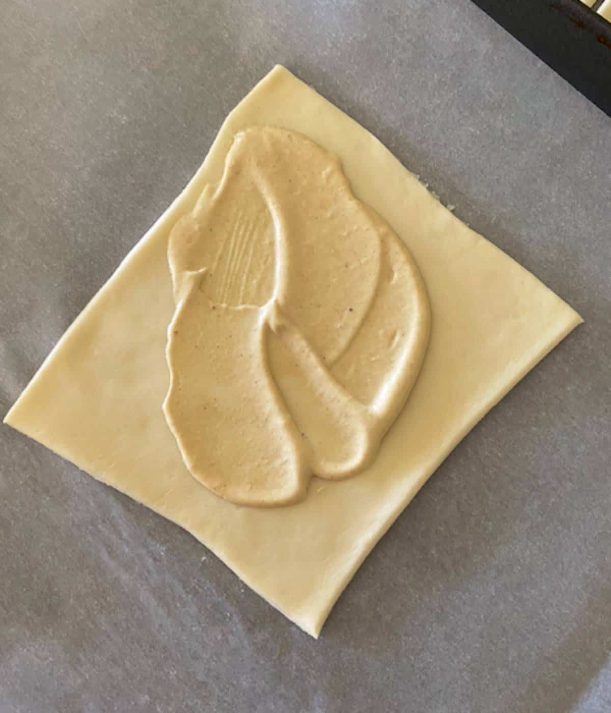 Puff pastry square with mayo mustard spread.