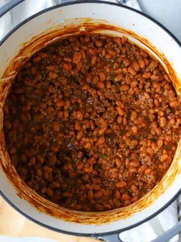 Baked beans with ground beef in dutch oven.
