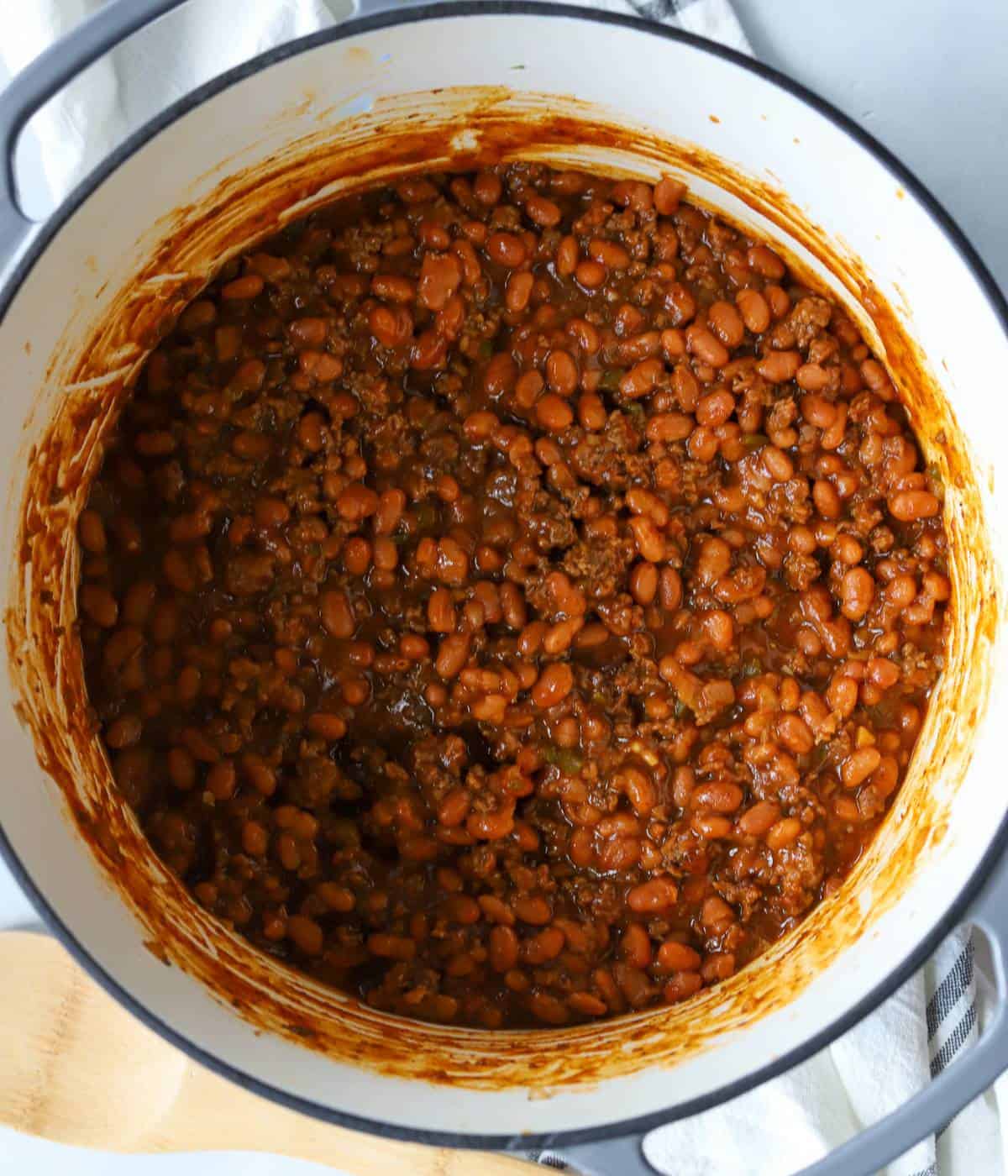 Baked beans with ground beef in dutch oven.