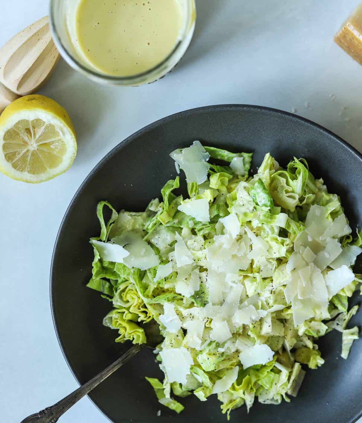 Caesar salad topped with caesar dressing with no anchovies in bowl.