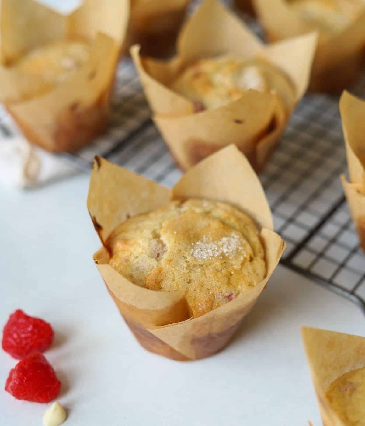 White chocolate muffins with raspberries in cupcake liner.