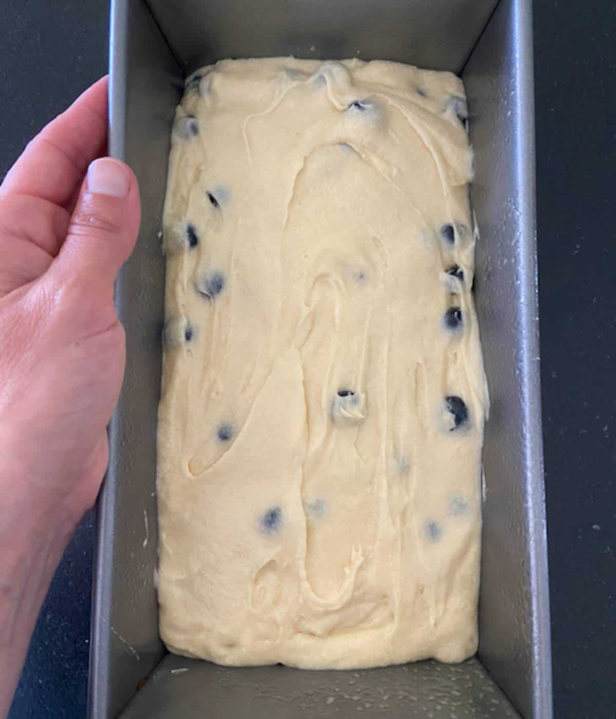 Blueberry pound cake batter in loaf pan.
