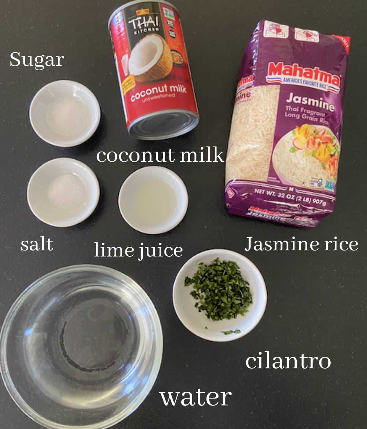 Coconut jasmine rice ingredients on black countertop.