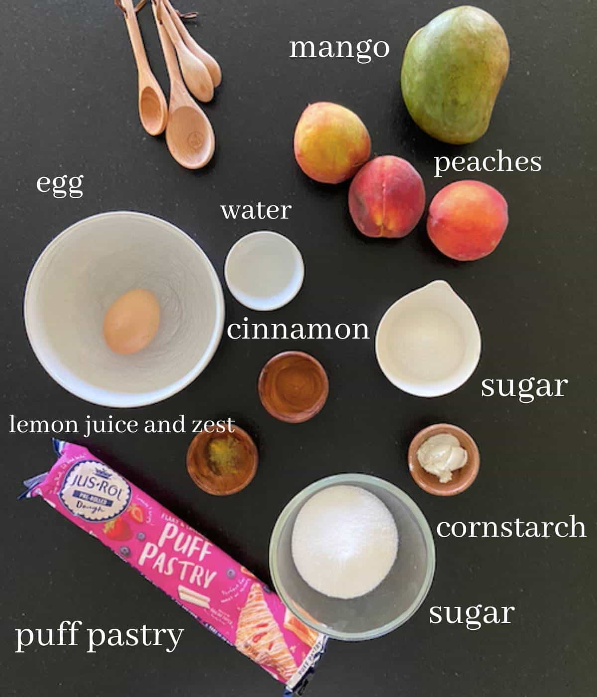 Ingredients for peach mango pie on black countertop.