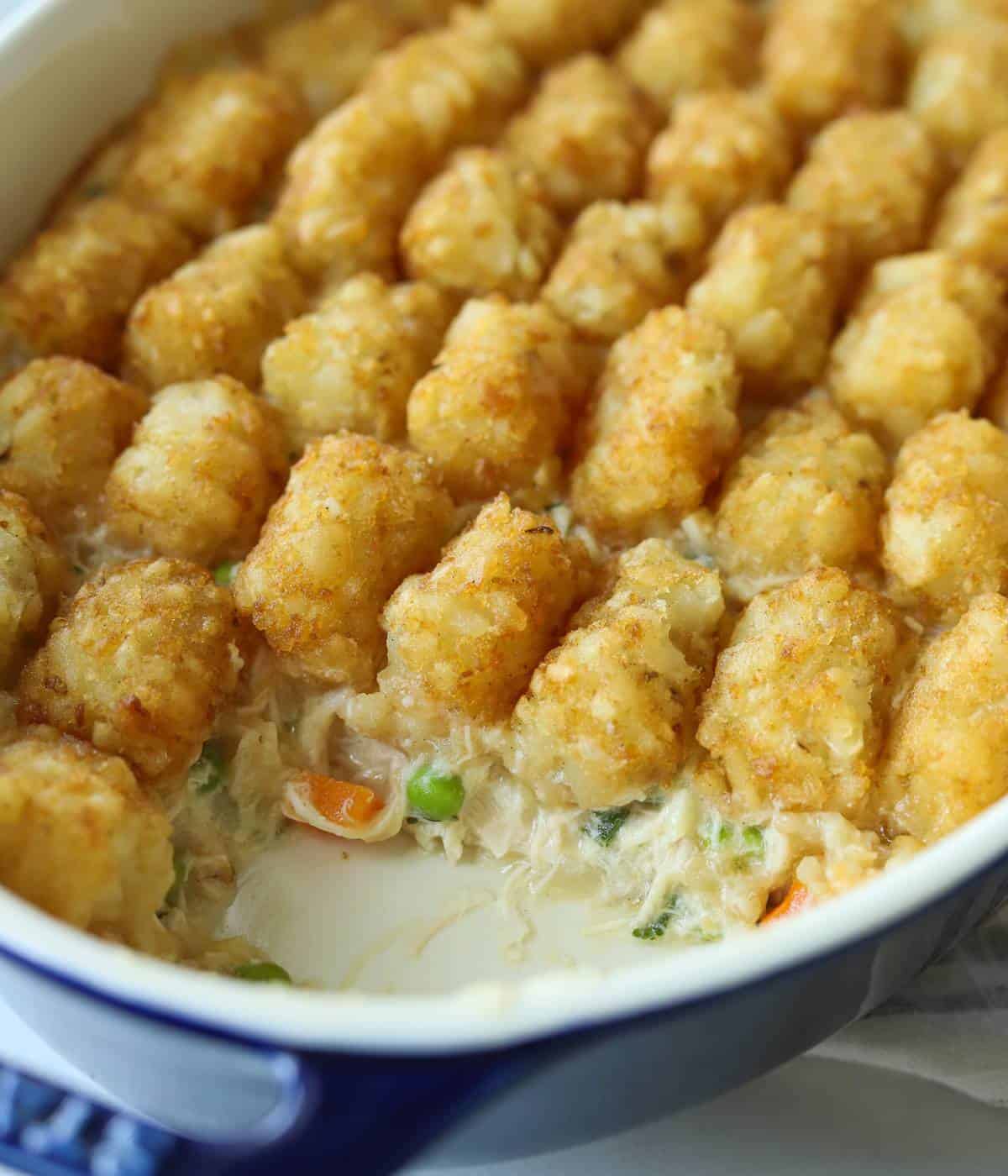 Tater tot casserole in dish with slice missing.