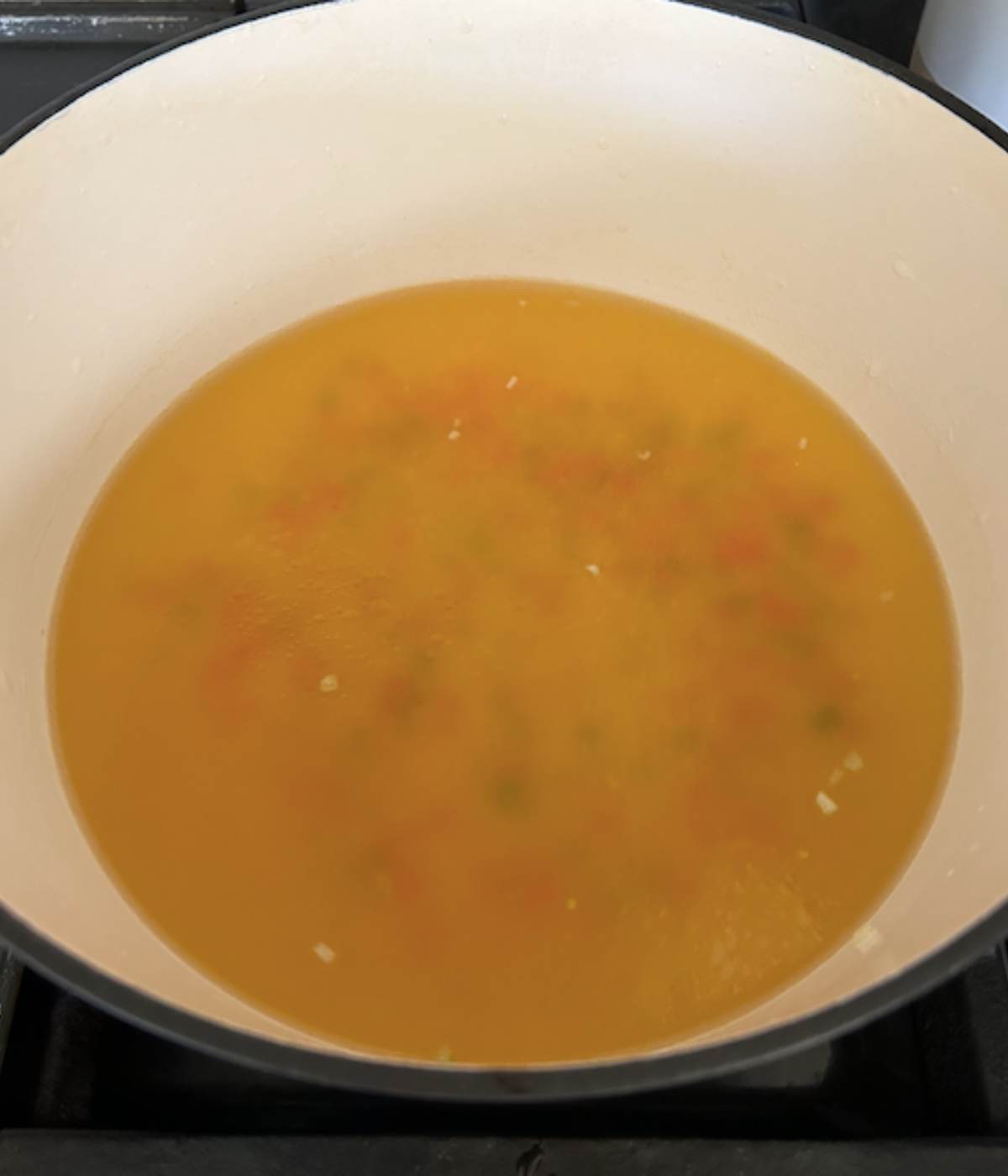 Chicken stock and vegetables in dutch oven.