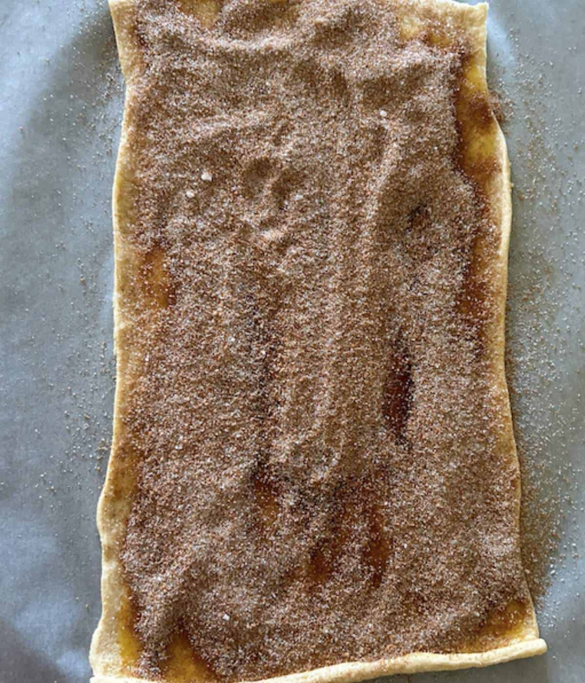 Dough covered with butter and cinnamon sugar mixture.