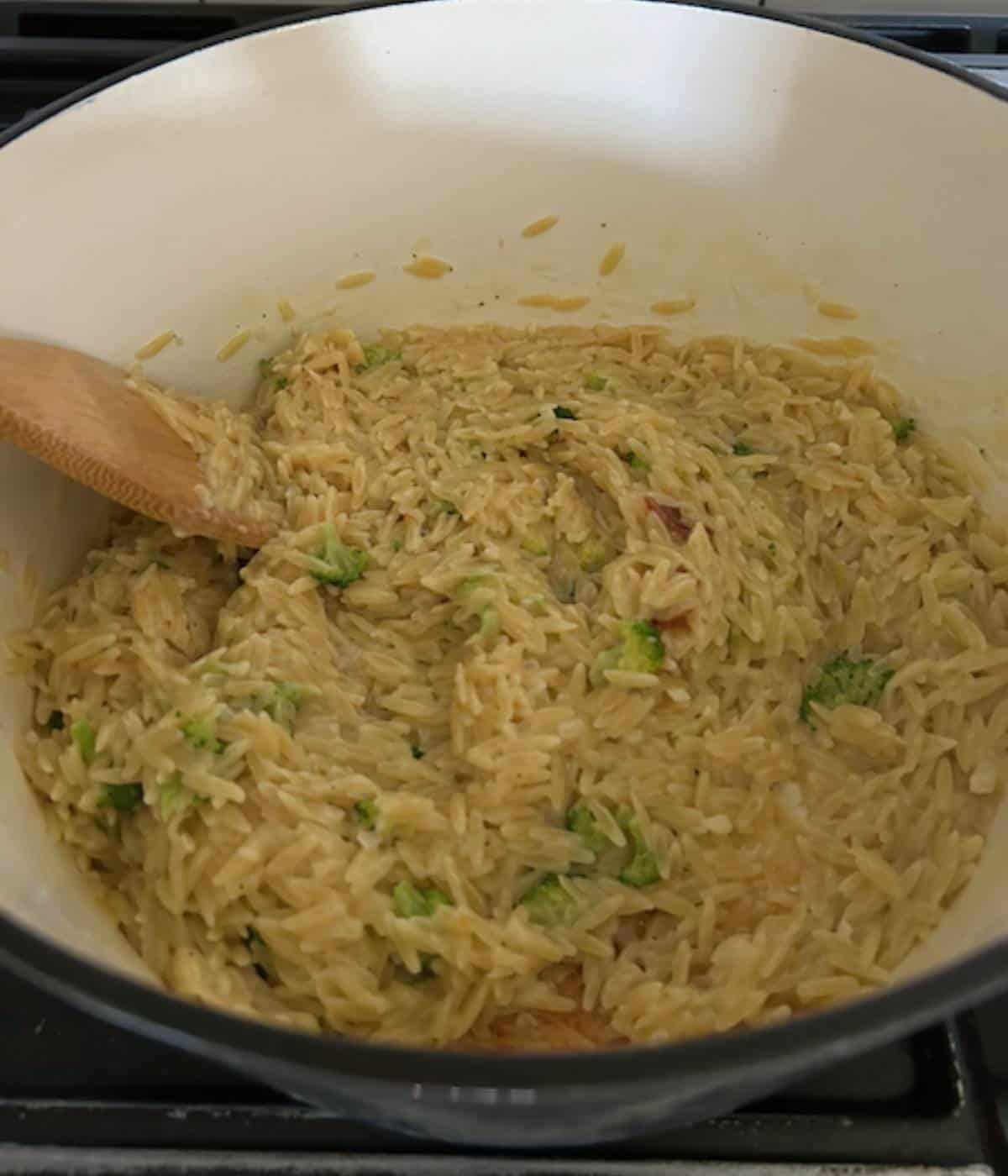Orzo broccoli in pot with wooden spoon.