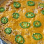 Jalapeno dip topped with melted cheese and jalapeno slices.