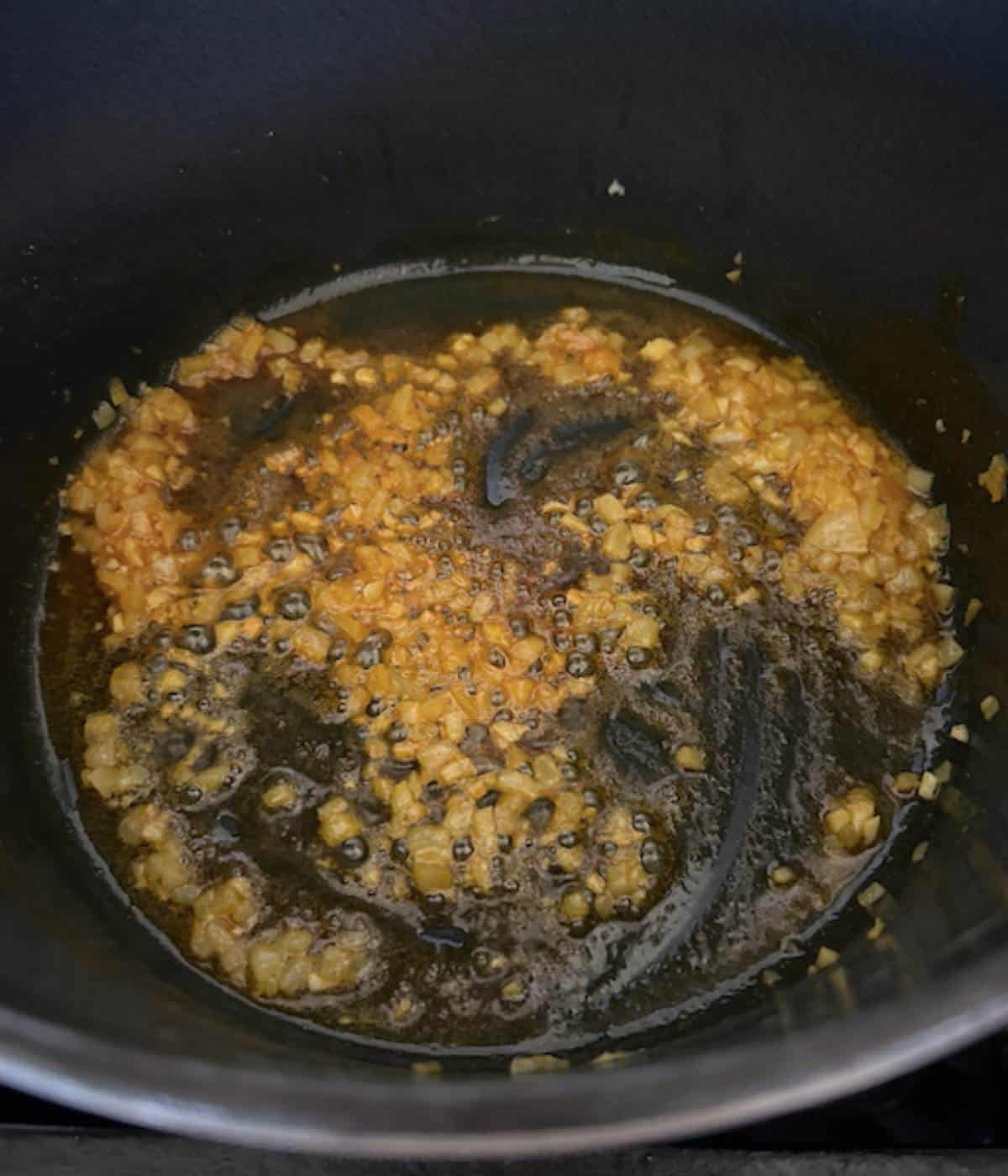 Onions, garlic and seasoning in dutch oven.