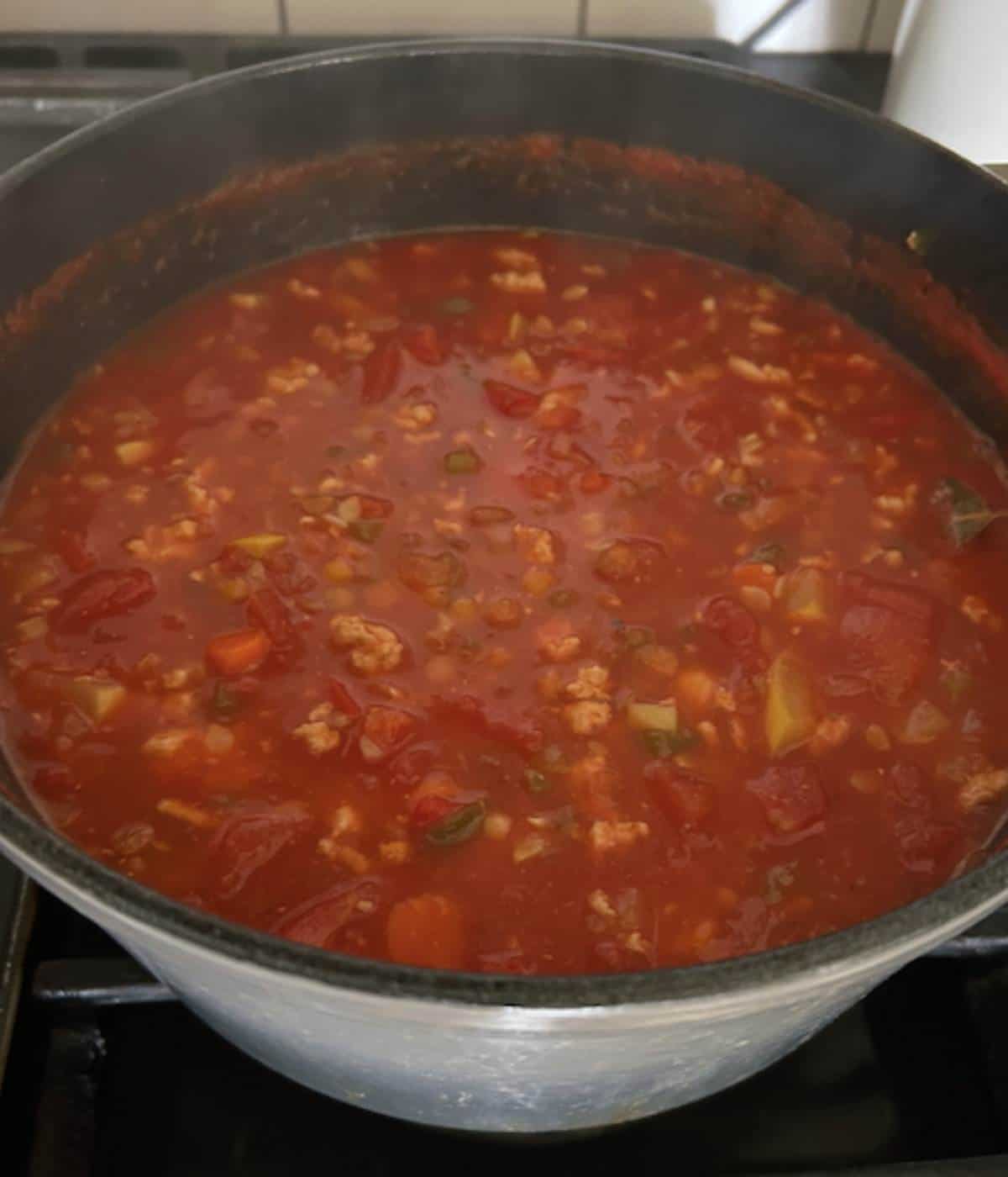 Turkey lentil soup in dutch oven cooking.