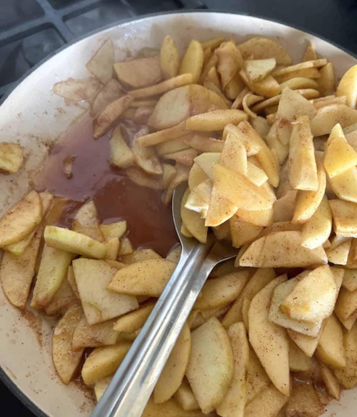 Apple filling ingredients cooking in skillet.