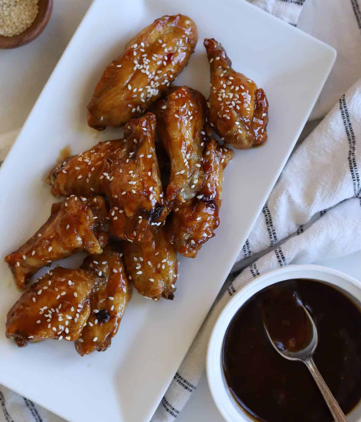 Garlic soy chicken wings on plate with side of garlic soy sauce.