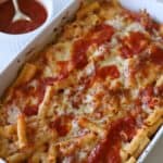 Meatless baked ziti in casserole dish with sauce on side.