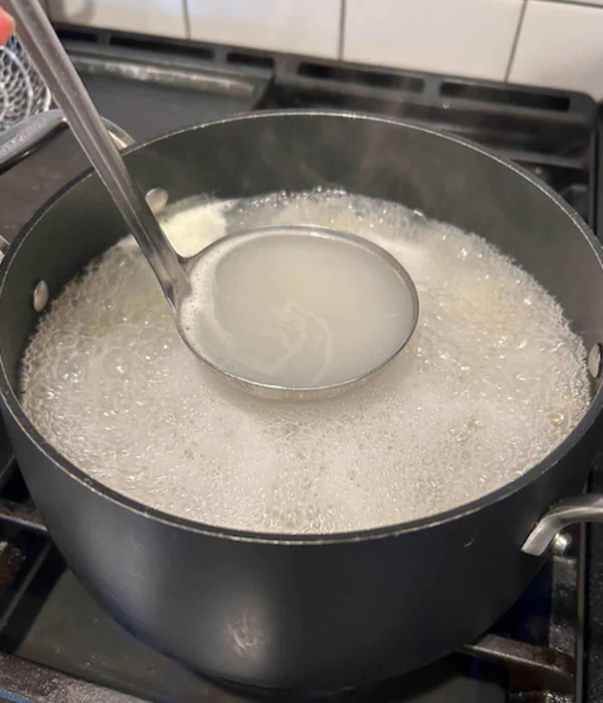 Ladle full of pasta water.