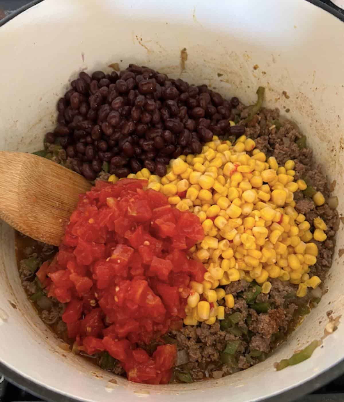 Corn, beans, and rotel on top of ground beef.