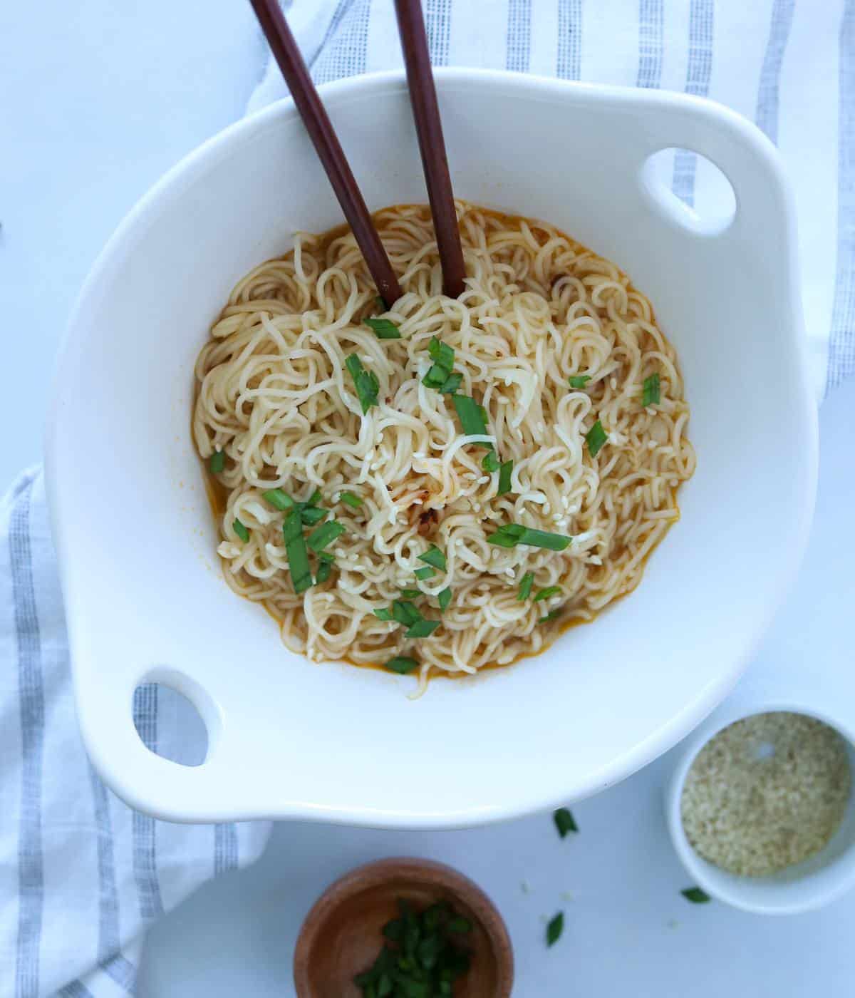 Chili oil ramen in white bowl with chopsticks. 