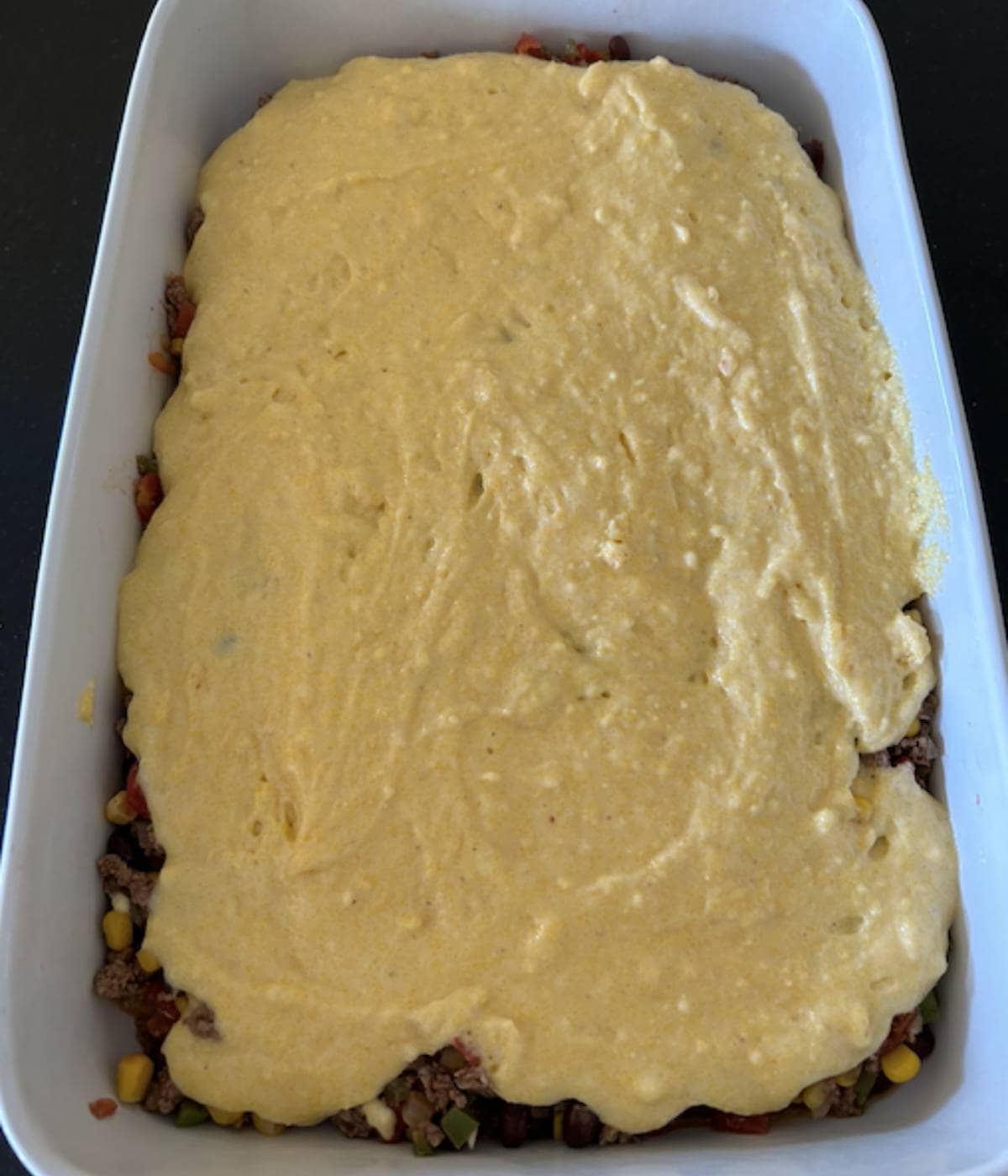 Cornbread covered over ground beef.