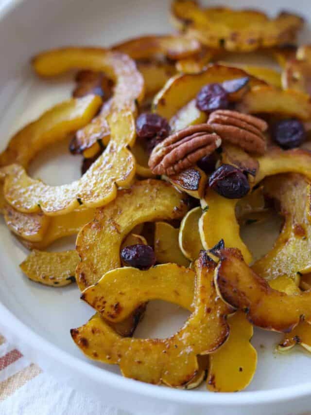 Delicata squash half moon slices in white bowl.