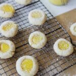 Lemon curd cookies topped with powdered sugar on baking rack.