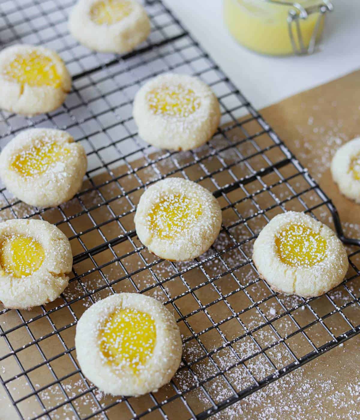 Lemon curd cookies topped with powdered sugar on baking rack. 